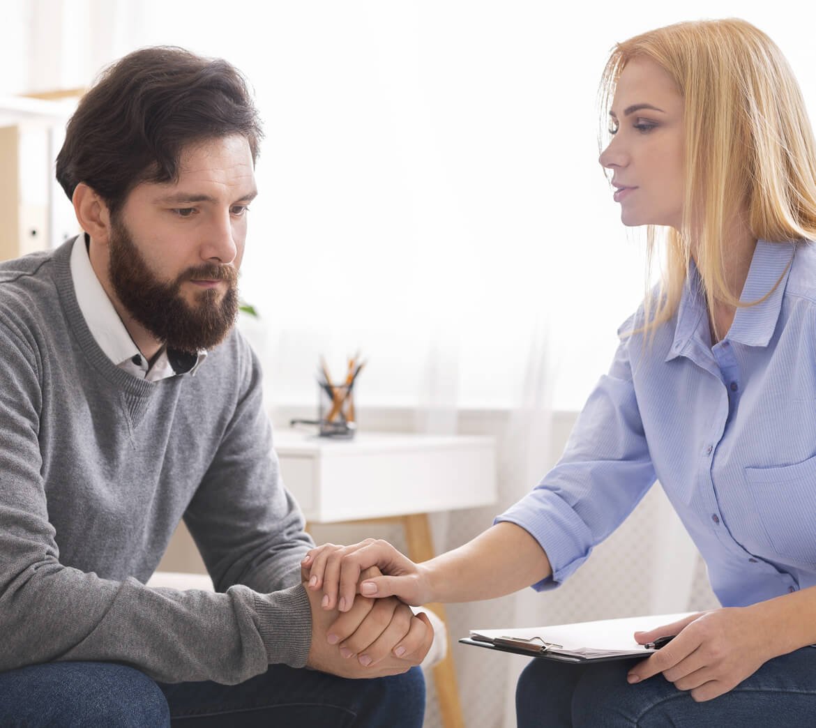 psychologist-comforting-depressed-man-patient-at-c-CRMC45F.jpg