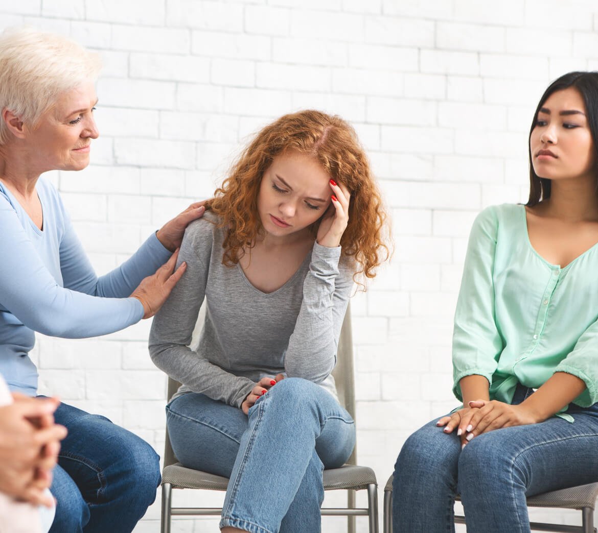 psychologist-supporting-depressed-girl-during-grou-7BKCVN6.jpg